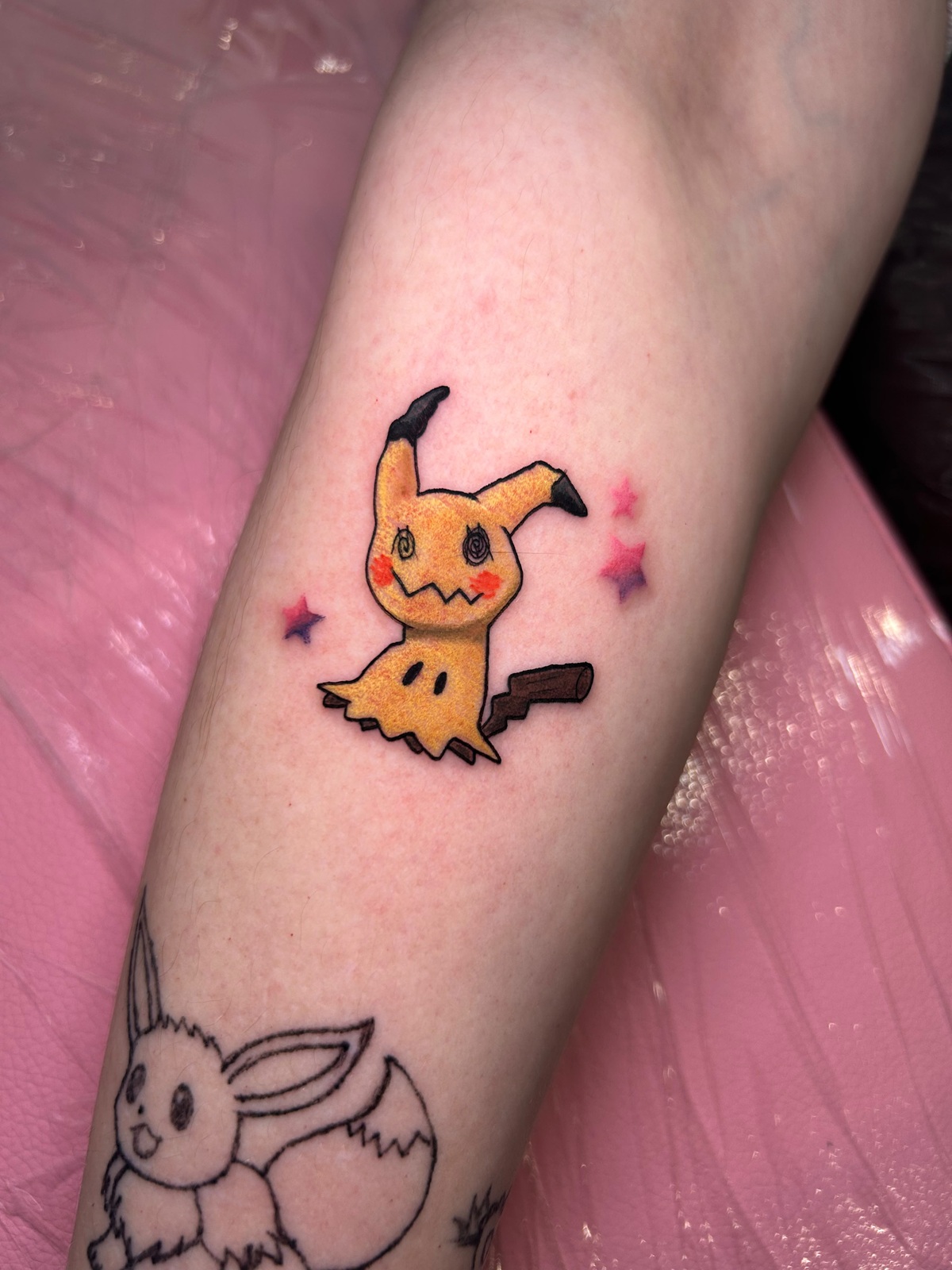 Tatuaggio di Mimikyu a colori, sull'avambraccio, realizzato alla Anime TattCon di Belfast