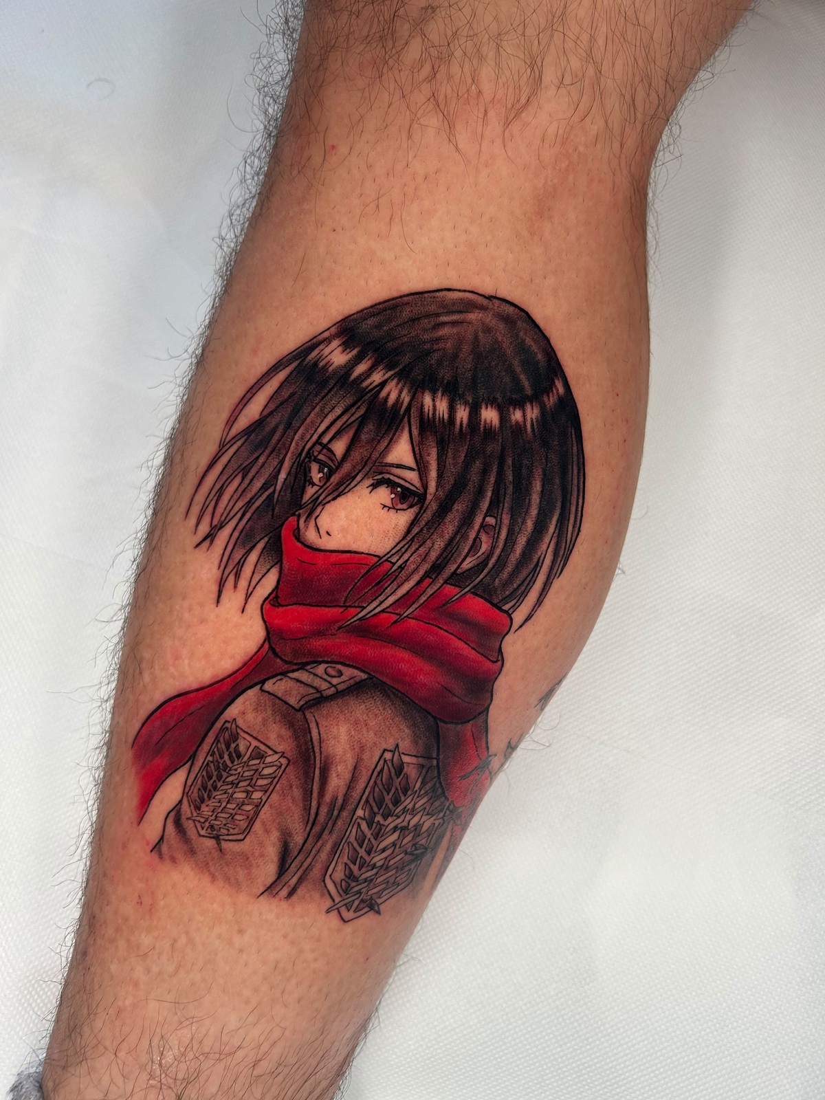 Tatuaggio di Mikasa Ackerman da L'Attacco dei Giganti, a colori, sul polpaccio