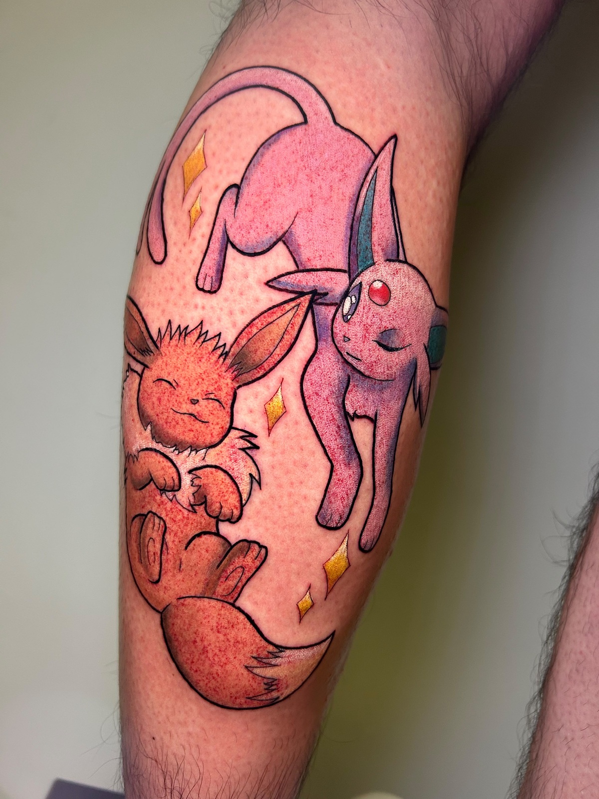 Tatuaggio di Eevee ed Espeon a colori, sul polpaccio